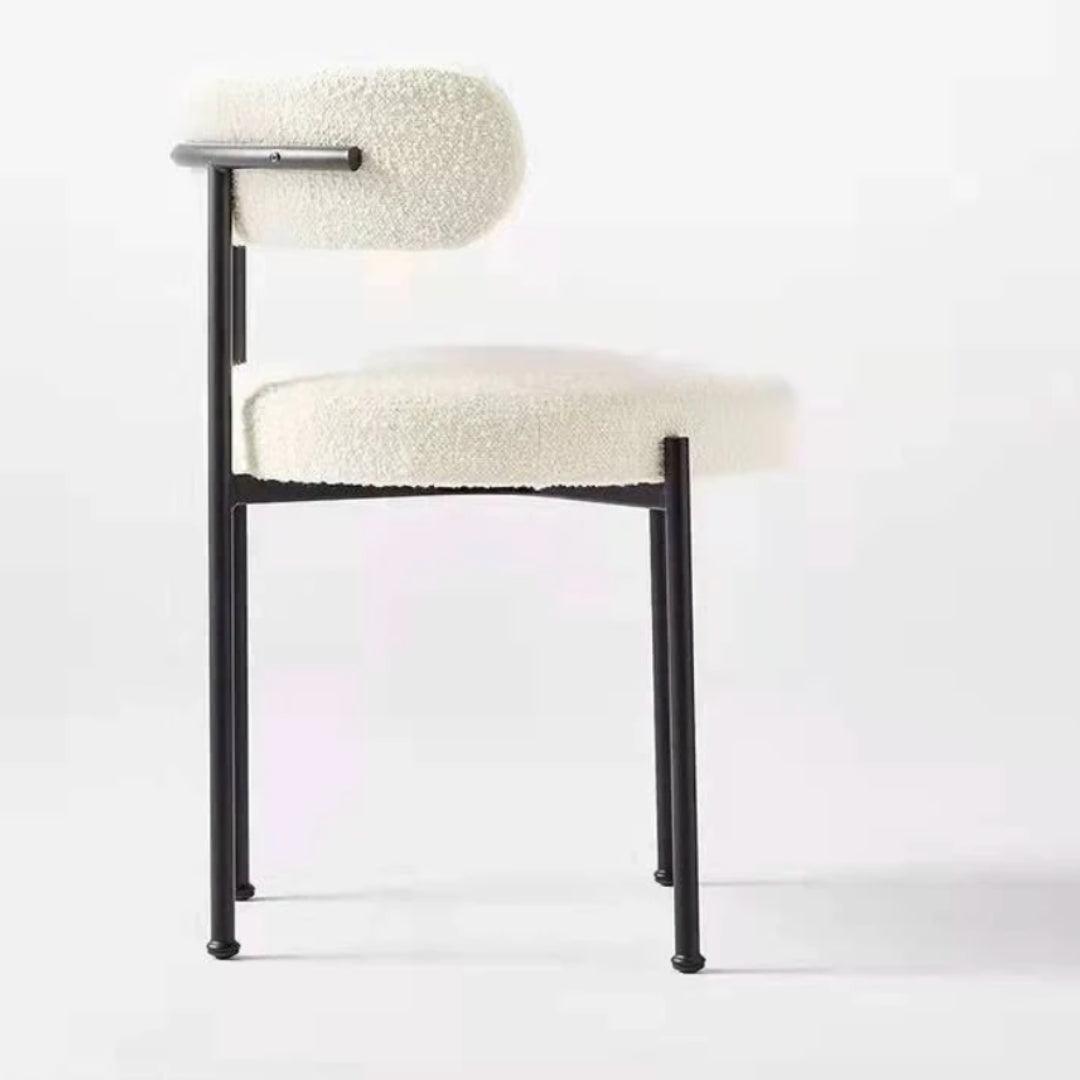 Side view of the Aria Boucle Dining Chair with black powder-coated steel legs and off-white boucle fabric, ideal for elegant dining spaces.